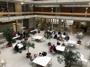 Im Foyer der Max-Weber-Schule in Freiburg helfen Schüler und Schülerinnen Menschen Ü60 bei Fragen zur Smatrphonenutzung.