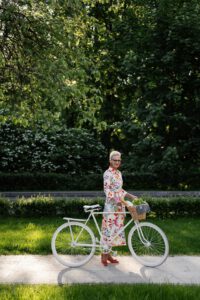 Das Bild zeigt eine Seniorin mit dme Fahrrad