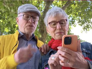 Hans und Ria Hinken in Freiburg. Blick auf das Smartphone für einen Filmbeitrag von Südbaden TV